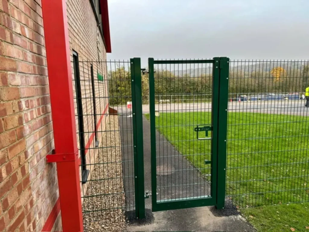 Green mesh pedestrian gate beside the factory building at Natures Bounty, Tring